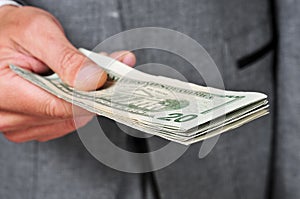 Man in suit with a wad of dollars