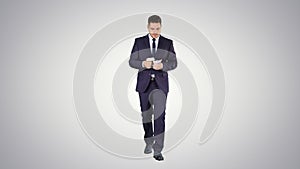 Man in suit walking and counting money on gradient background.