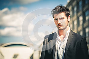 Man in suit and white shirt looking. Outdoors on the street in the city