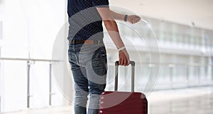 Man with suitcase holding plastic key to hotel room closeup