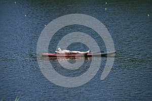 Man sunbathing lying on a SUP board on a water of a river