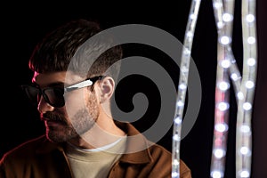 Man in sunglasses over neon lights at nightclub