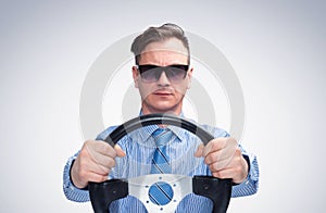 Man in sunglasses in a shirt and tie holds the steering wheel. Front view. Car driver concept