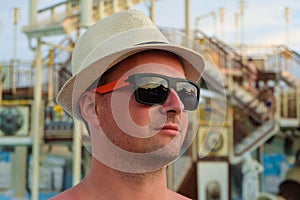 Man in the sunglasses and straw hat looks into the distance