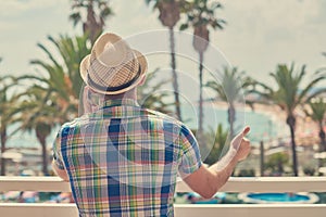 Man in sunhat calling using cellphone against beautiful sea view photo