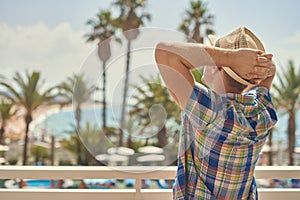 Man in sunhat relaxing against amazing sea view