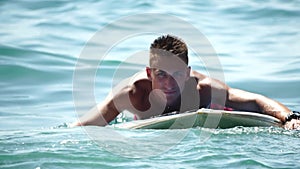 Man Sup Sea. Strong athletic man learns to paddle sup standing on board in open sea ocean on sunny day. Summer holiday