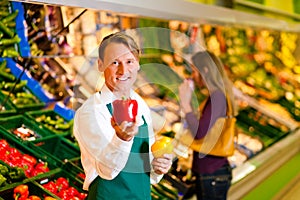 Man in supermarket as shop assistant