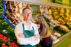 Man in supermarket as shop assistant