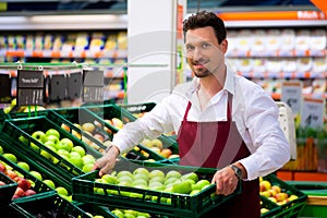 Man in supermarket as shop assistant