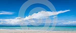 Man in the surf. Warm afternoon on the beach in Cuba. A man walks in the gentle ocean surf in Varadero.