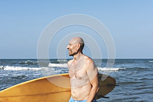 A man with a surfboard by the coast