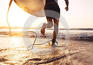 Man surfer run in ocean with surfboard. Active vacation, health