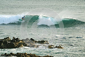 Man surfing on the breaking waves in Pacific Ocean at Hanga Roa, Easter Island, Chile, South America