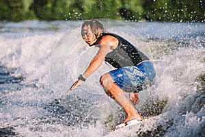 A man is surfing on a surfboard drawn by a motor boat above the wave of the boat. Weixerfer is engaged in surfing, entertainment,