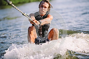 A man is surfing on a surfboard drawn by a motor boat above the wave of the boat. Weixerfer is engaged in surfing, entertainment,