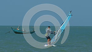 Man Surfs Holding to Sails Boat Wallows in Ocean