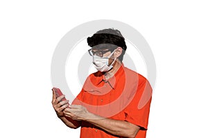 Man with surgical mask while using smarthpone to send messages o