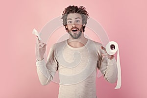 Man with surprised face hold toilet paper. Pandemic. Man in underwear with disheveled hair, morning. Sterility and photo