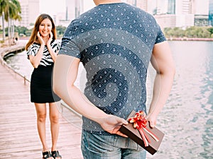 Man surprises his girlfriend by giving out a gift - love and relationship concept