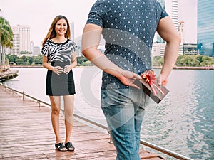 Man surprises his girlfriend by giving out a gift - love and relationship concept