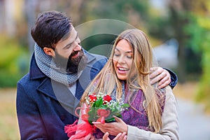 Man Surprises woman With Flowers in the park