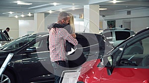 Man Surprising Woman with New Car In Show Room