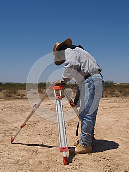 Man Surveying at Excavation Site - Vertical