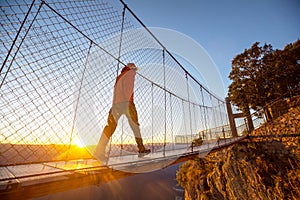 Man on suspension bridge photo