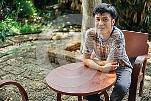 Man sweating sitting on the wood chair at the garden