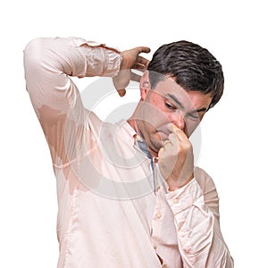 Man with sweating under armpit pinches nose with fingers