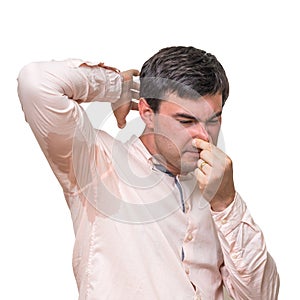 Man with sweating under armpit pinches nose with fingers