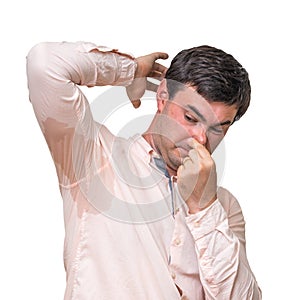 Man with sweating under armpit pinches nose with fingers photo