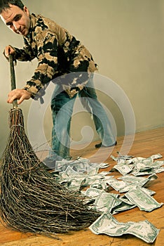 Man sweeping dollar banknotes