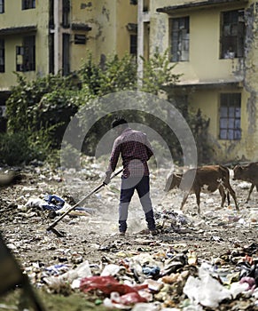 December, 2022, Raipur, India: Man sweeping the trash with broom , Man cleaning the polluted area, Pollution control day,