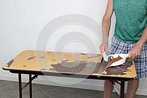 Man Sweeps Debris Off a Table Top Heâ€™s Resurfacing