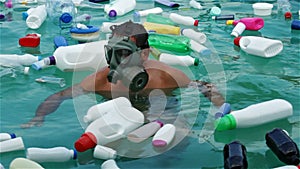 Man swim in plastic polluted water using protecting mask