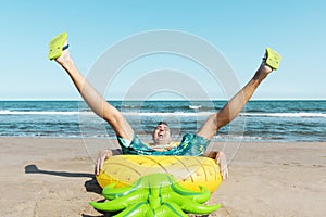 Man on a swim ring in the shape of a pineapple