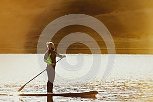 Man swim sup paddle board sunset