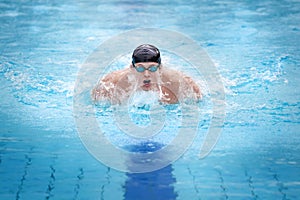 Man swimmer in cap taking breath