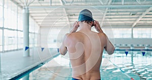 Man, swimmer and preparing at indoor pool for exercise, training or sports for fitness or wellness. Male athlete