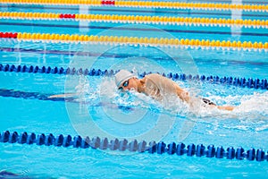 Man swimmer swimming crawl in blue water.