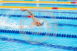 Man swimmer swimming crawl in blue water.