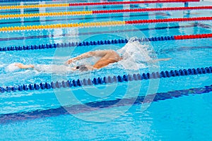 Man swimmer swimming crawl in blue water.