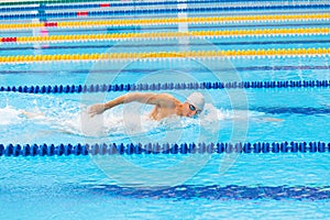 Man swimmer swimming crawl in blue water.