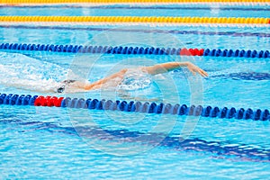 Man swimmer swimming crawl in blue water.