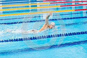 Man swimmer swimming crawl in blue water.