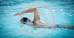 Man swimmer swimming crawl in a blue water pool