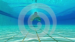 Man swimmer swimming in the swimming pool under water