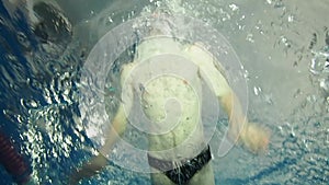 Man swimmer swims butterfly stroke in a swimming pool slow motion underwater